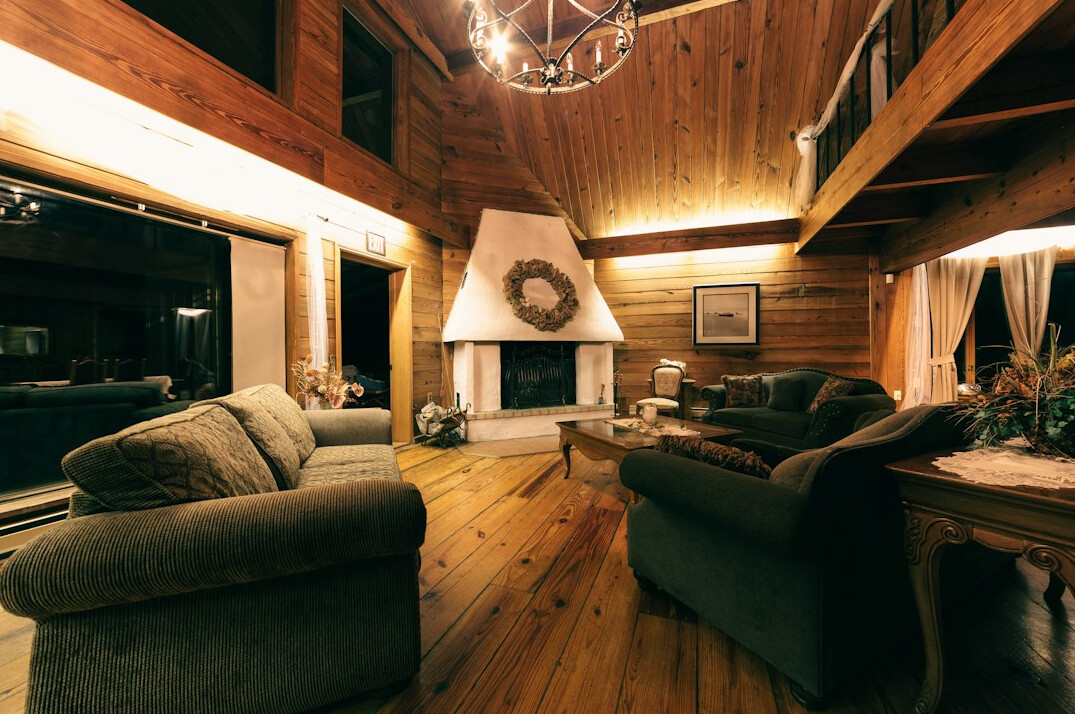Intérieur chaleureux d'un chalet suisse avec poutres en bois et cheminée en pierre